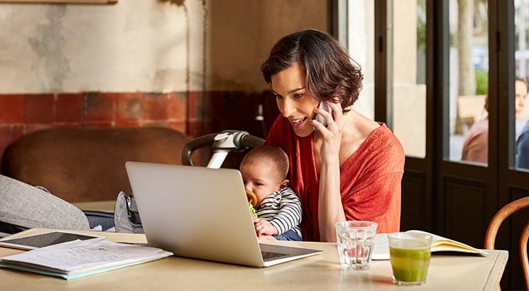 Woman using phone and laptop